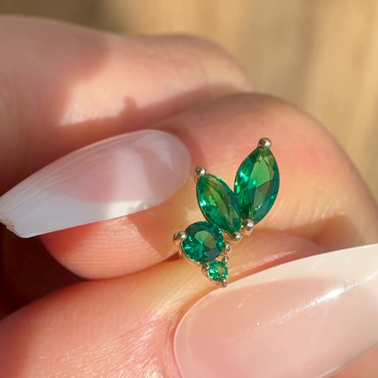 a close up of a person's hand with a green ring