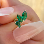 a close up of a person's hand holding a green ring