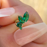 a close up of a person's hand holding a green ring