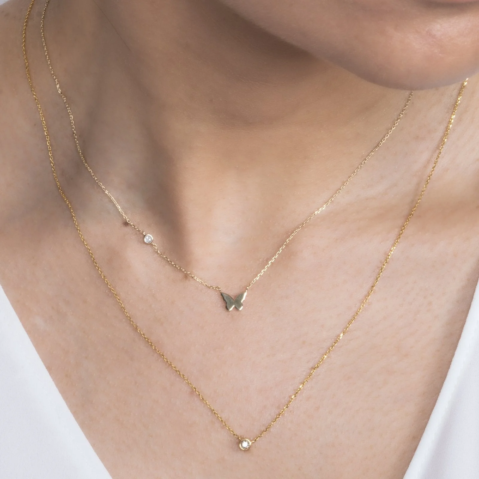 A woman wearing the Bubble Butterfly and Diamond Station Necklace
