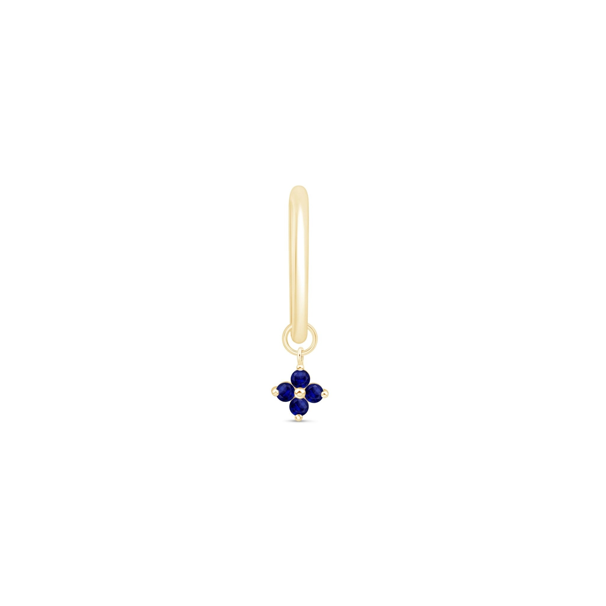 a gold earring with a blue flower