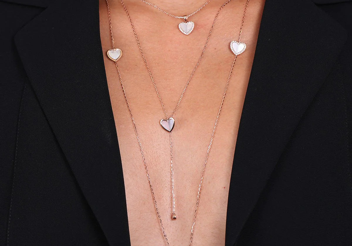 A woman wearing the Mother of Pearl Heart with Diamond Halo Pendant Necklace