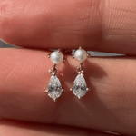 a person holding a pair of earrings in their hand