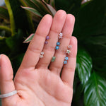 a person's hand holding three different colored rings