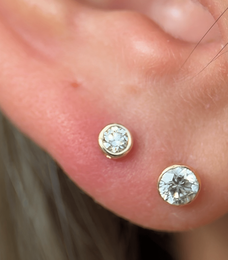 a close up of a person wearing a pair of ear piercings