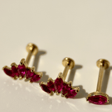 three pairs of pink stoned earrings on a white surface