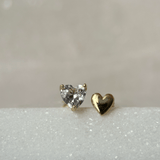 a pair of diamond earrings sitting on top of a white surface