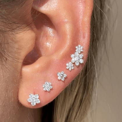 a close up of a person wearing a pair of ear piercings