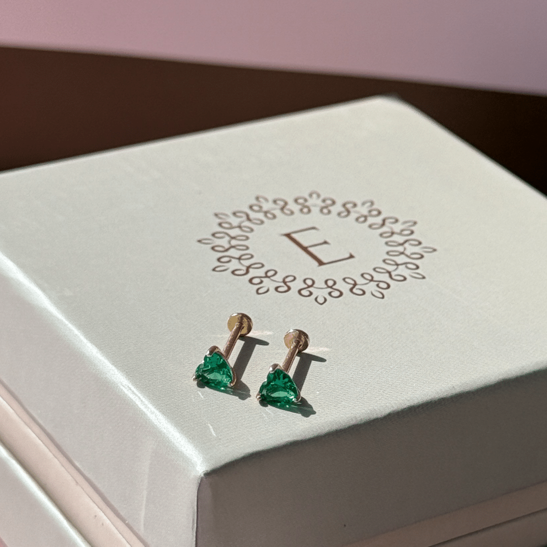 a white clock sitting on top of a pink box