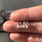 a woman's hand with three pearls on it