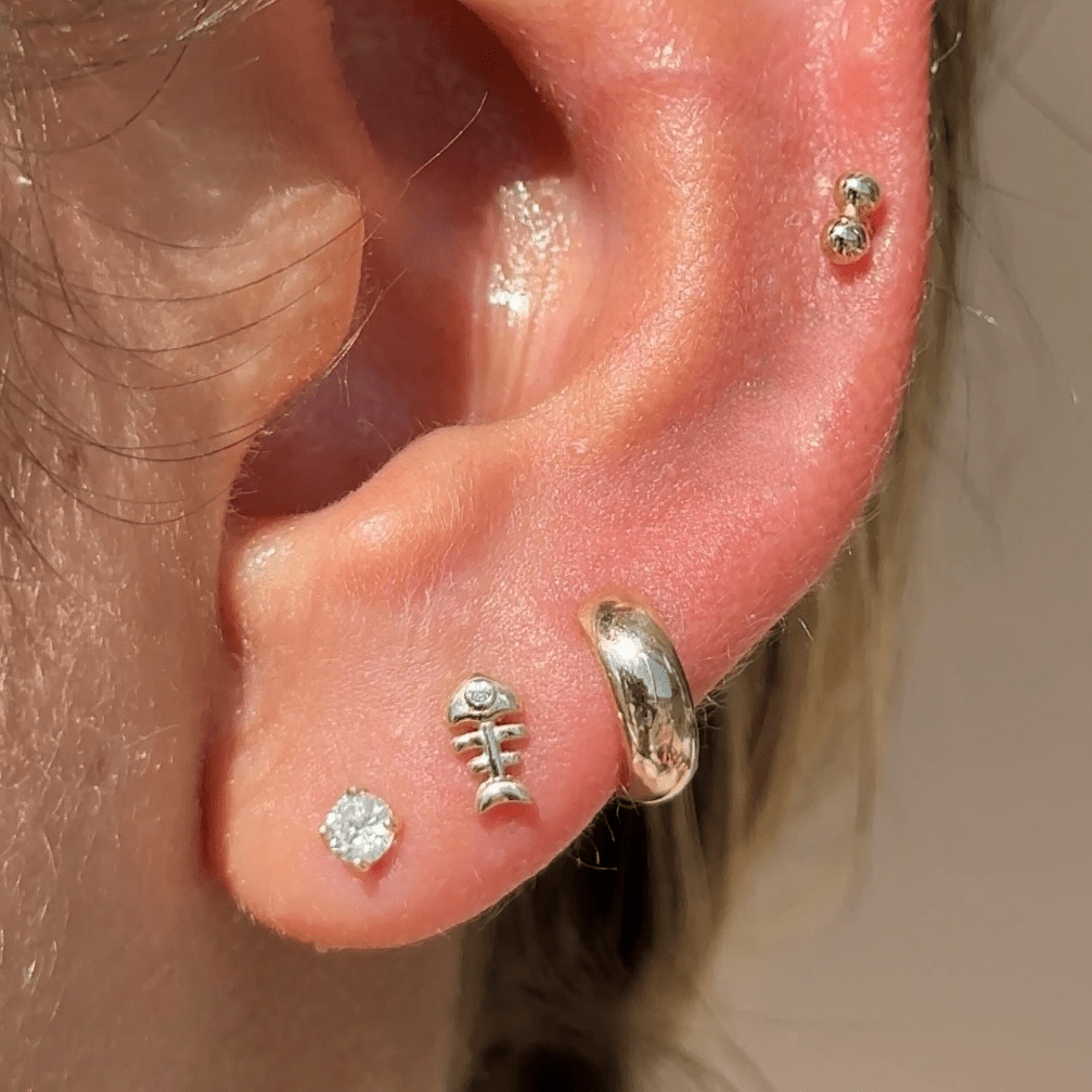 a close up of a person wearing a pair of ear piercings