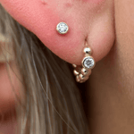 a close up of a person wearing a pair of ear piercings