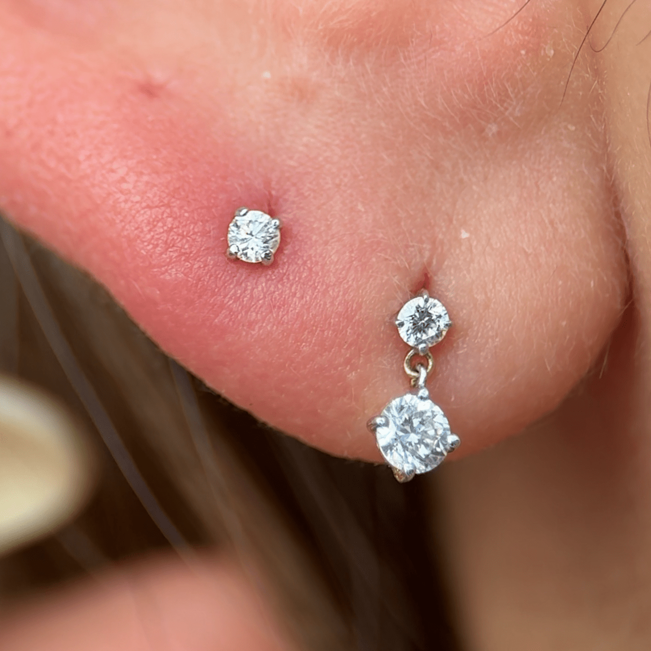 a close up of a person wearing a pair of ear piercings