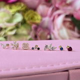 a close up of three pairs of earrings on a pink box