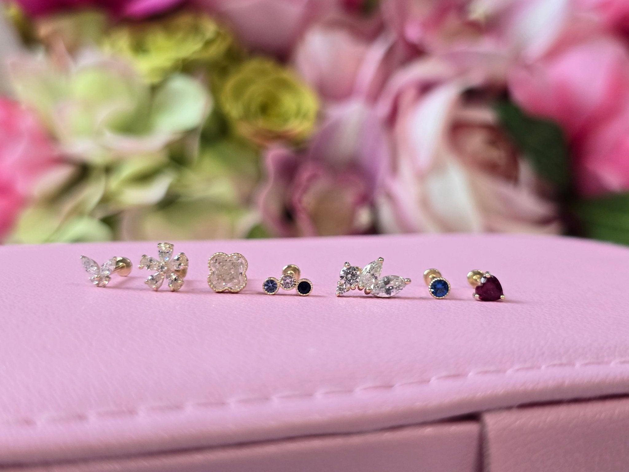 a close up of three pairs of earrings on a pink box