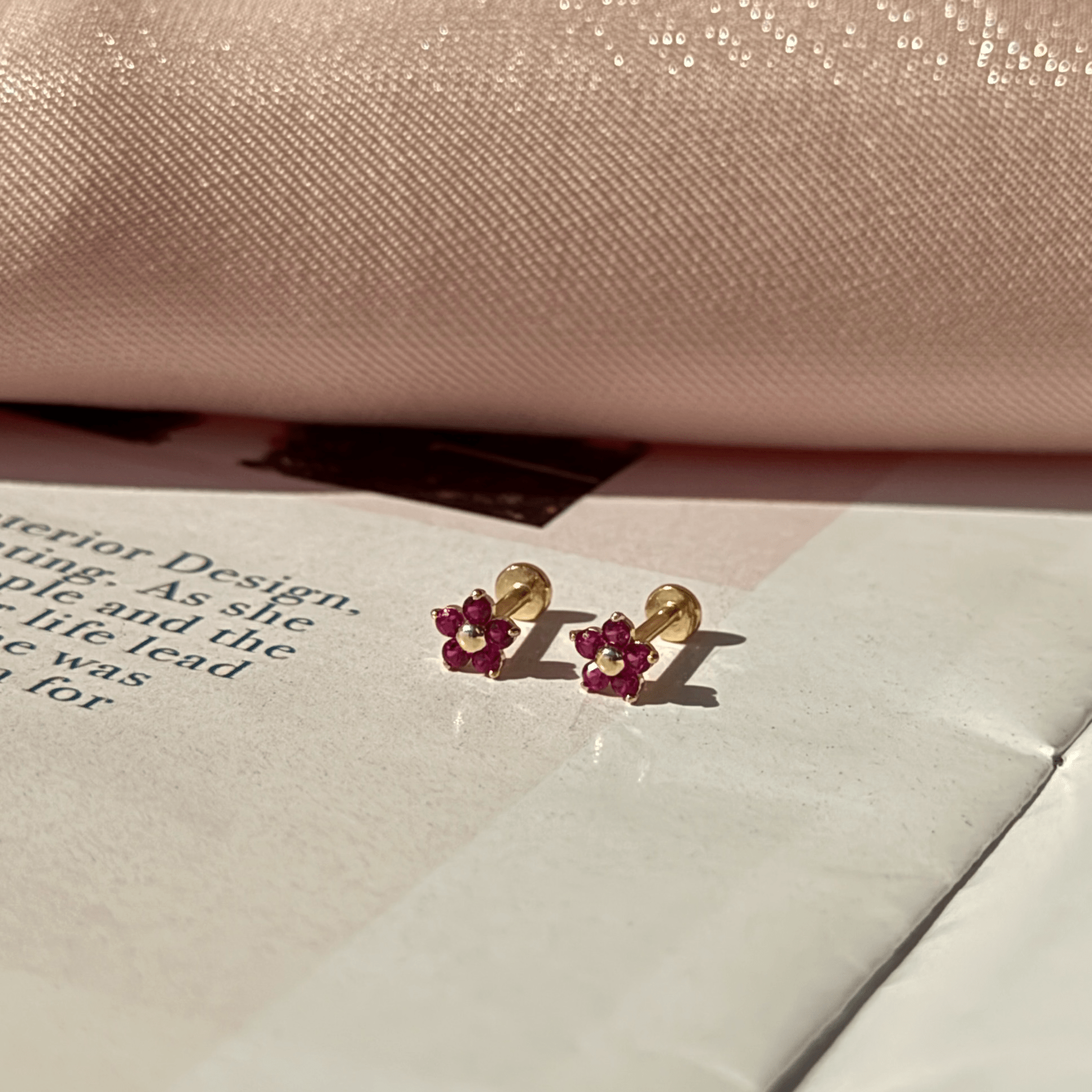 a pair of earrings sitting on top of a book