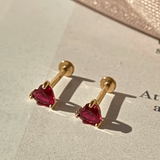 a pair of earrings sitting on top of a piece of paper