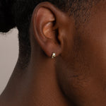 a close up of a person wearing a pair of earrings