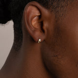 a close up of a person wearing a pair of earrings