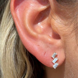 a close up of a person wearing a pair of earrings