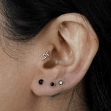 a close up of a person wearing a pair of ear piercings