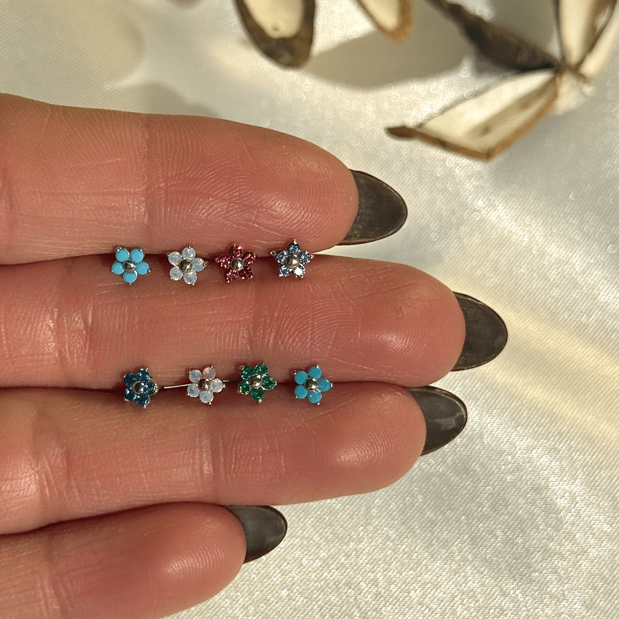 a woman's hand with three different colored flowers on it