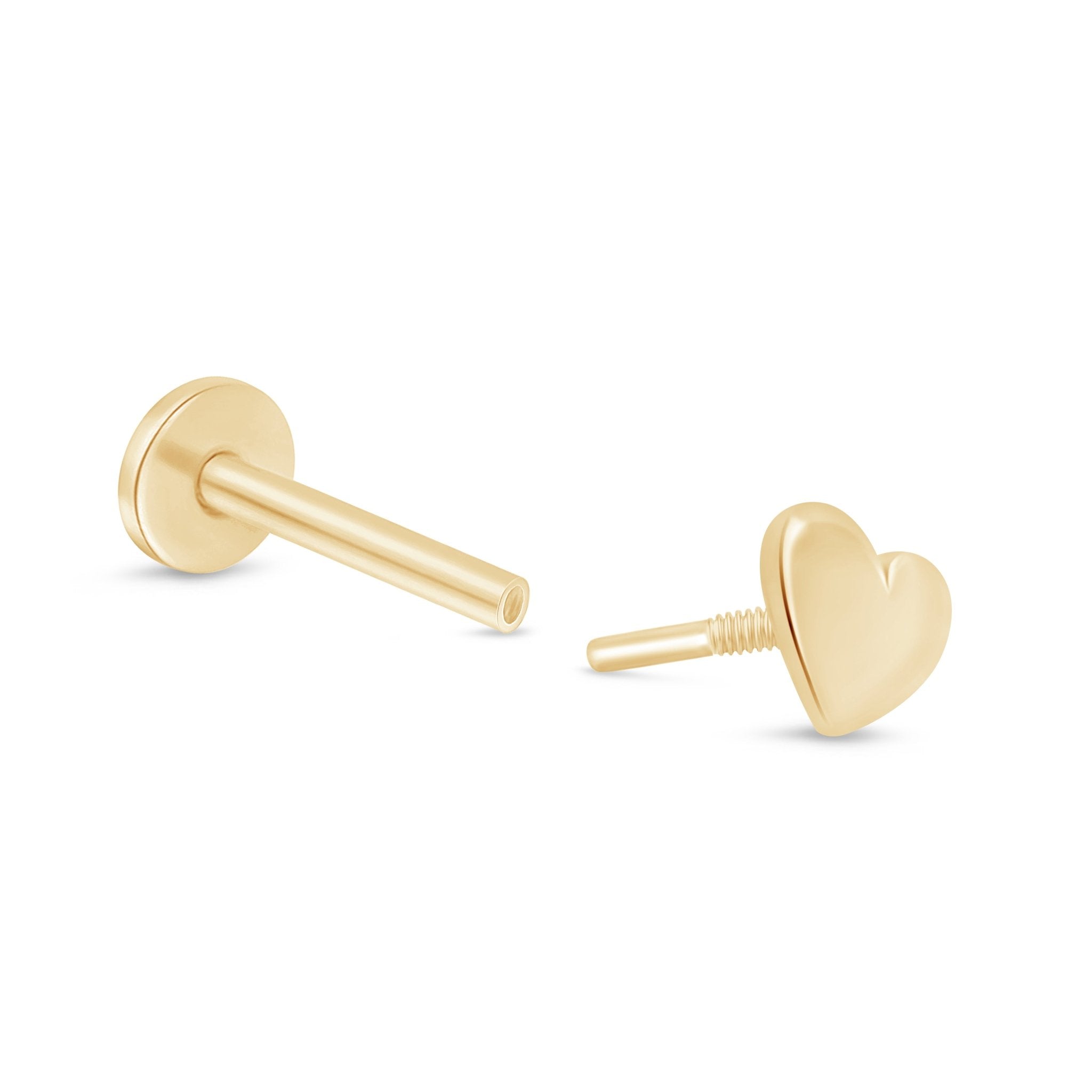 a pair of gold heart earrings on a white background