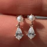 a person holding a pair of earrings in their hand