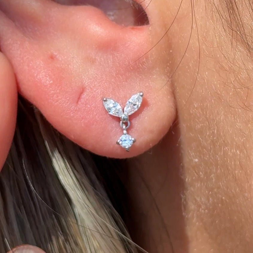 a close up of a person wearing a pair of ear piercings