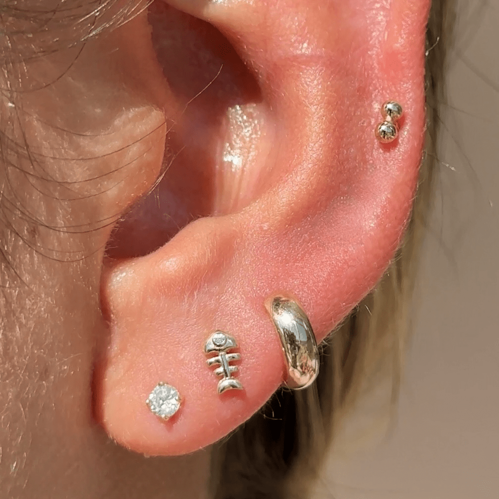 a close up of a person wearing a pair of ear piercings