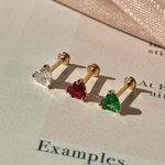 three pairs of earrings sitting on top of a piece of paper