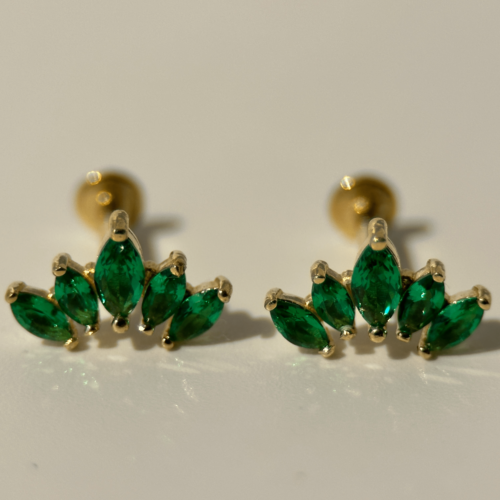 a pair of green earrings sitting on top of a table