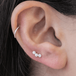 a close up of a person wearing a pair of ear piercings