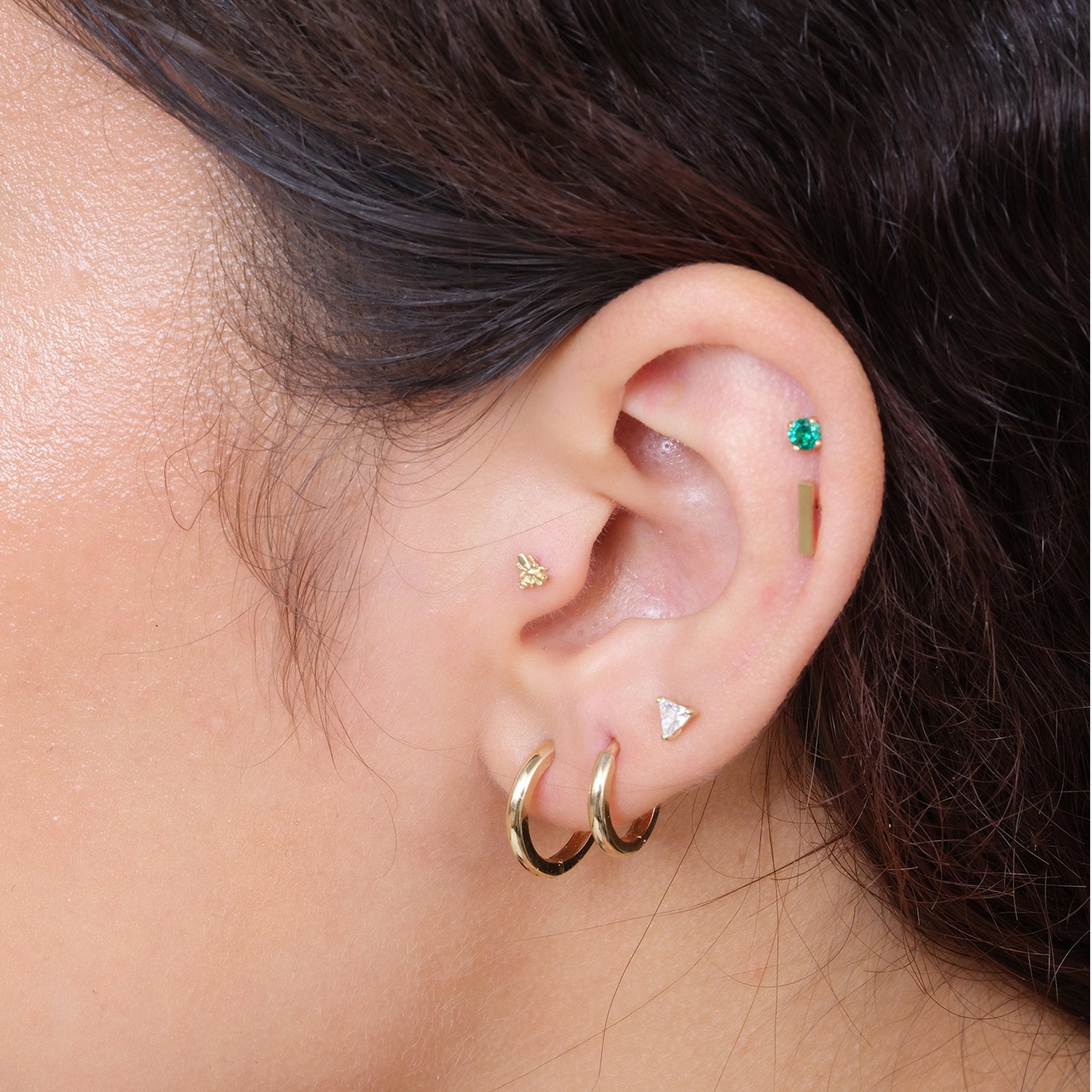 a close up of a person wearing a pair of ear piercings