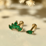 a pair of green earrings sitting on top of a table