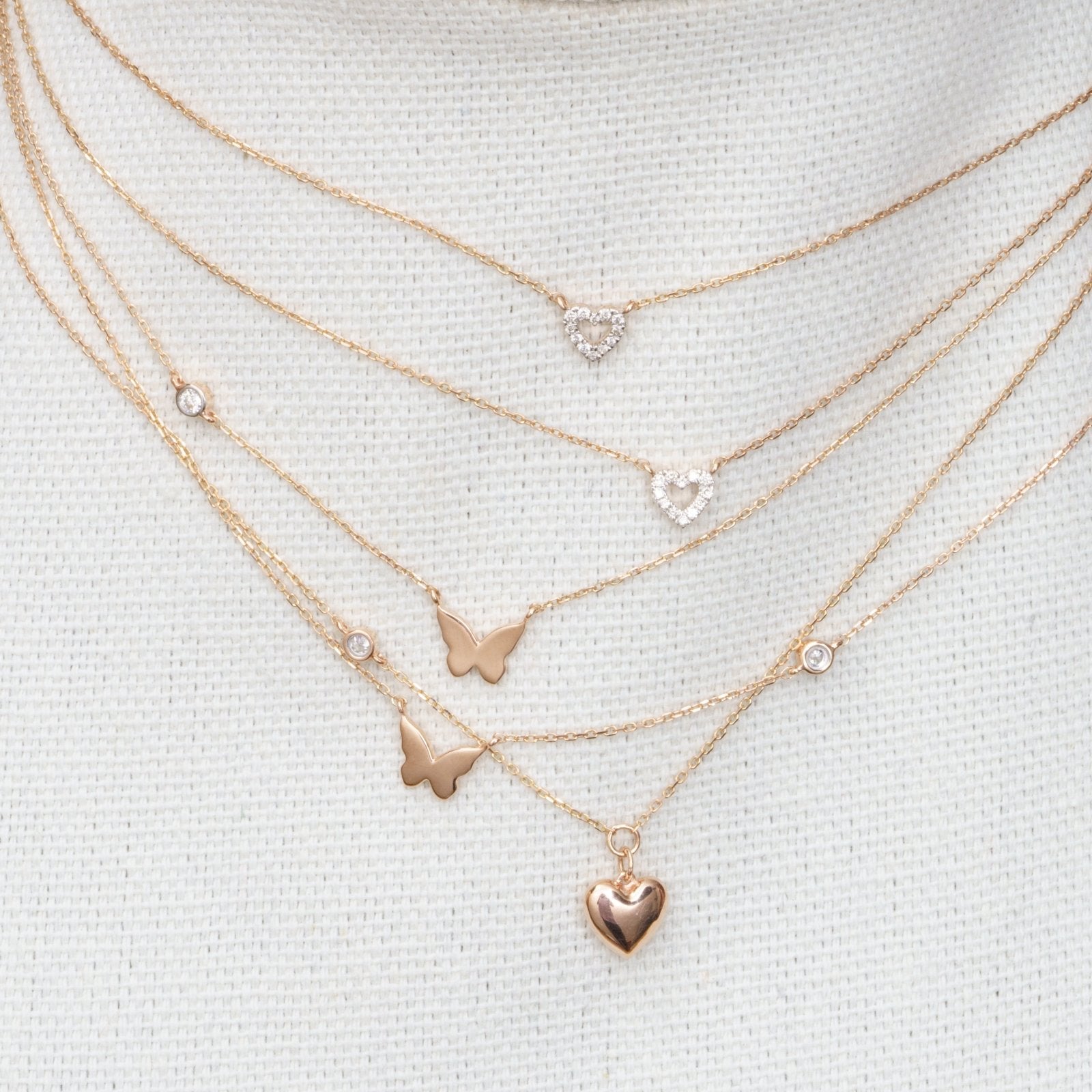 butterfly and heart necklaces in rose gold.