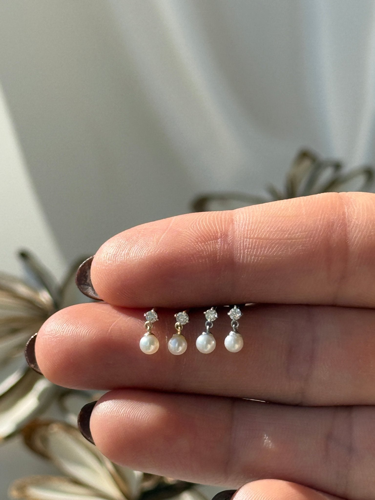 a woman's hand holding a ring with pearls on it