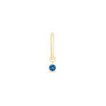 a gold earring with a blue stone