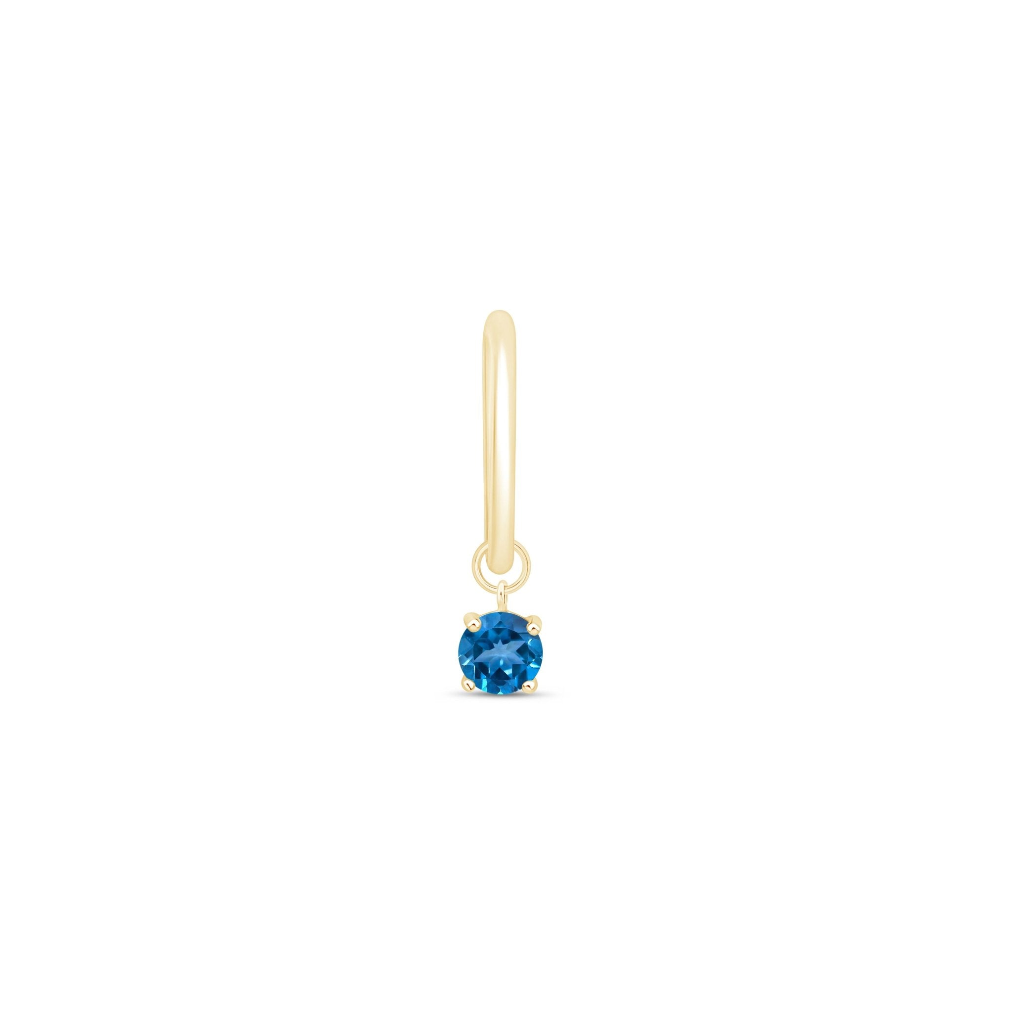 a pair of gold earrings with a blue stone