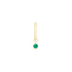 a gold earring with a green stone