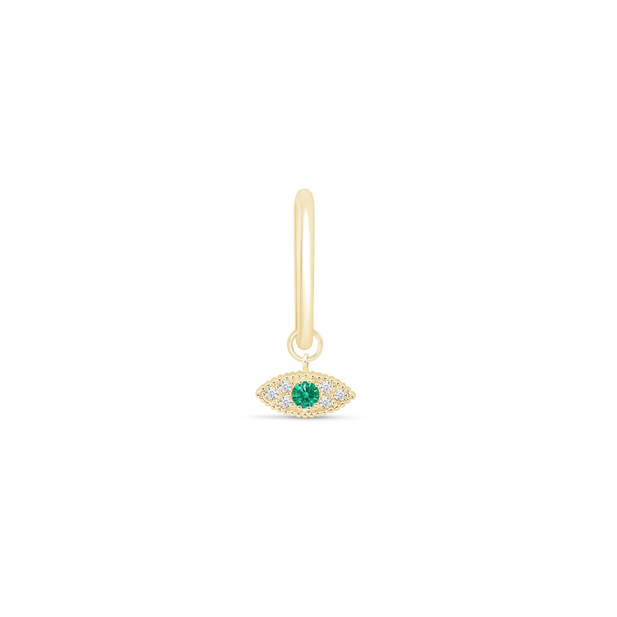 a gold earring with an evil eye charm