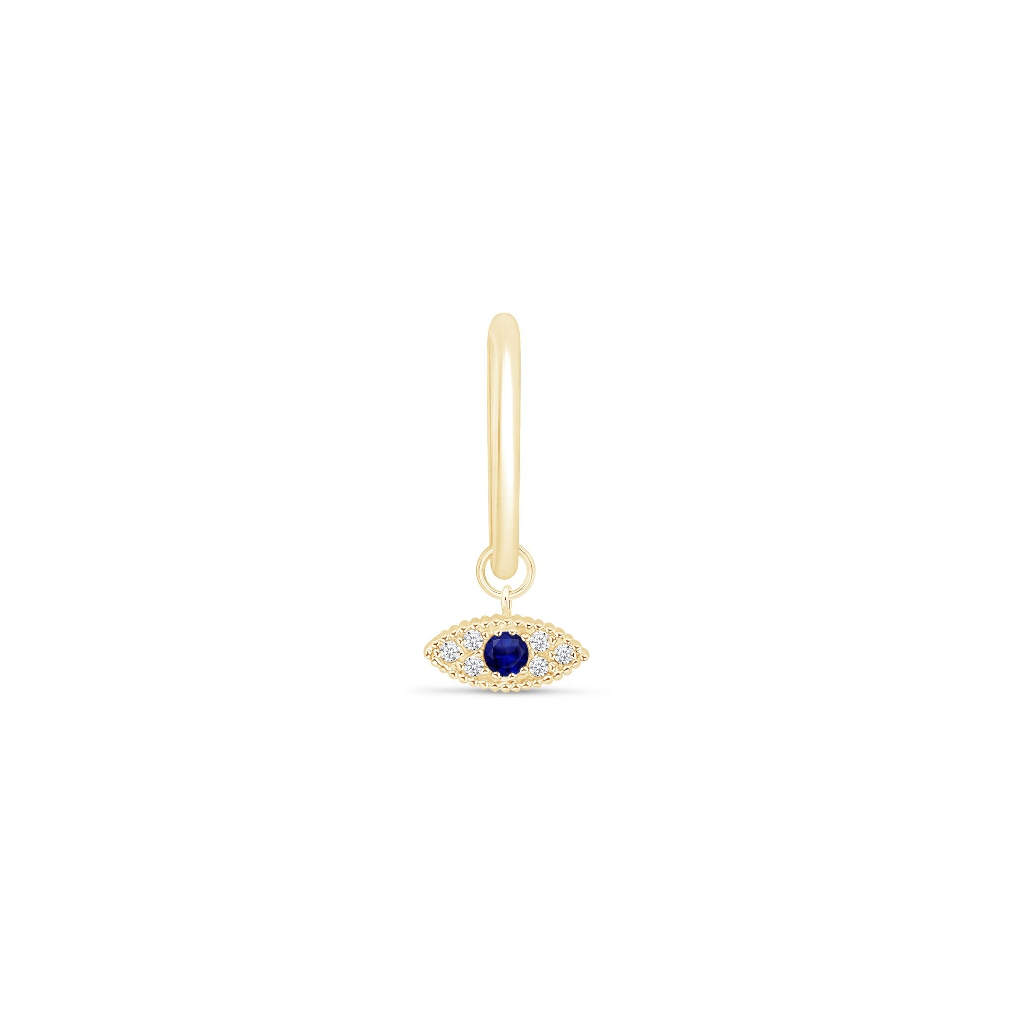 a gold earring with an evil eye charm