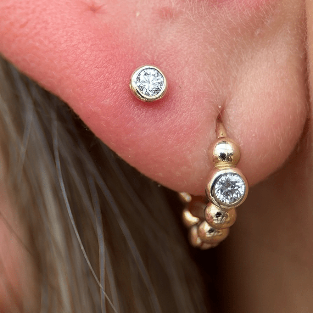 a close up of a person wearing a pair of ear piercings