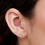 a close up of a person wearing a pair of ear piercings