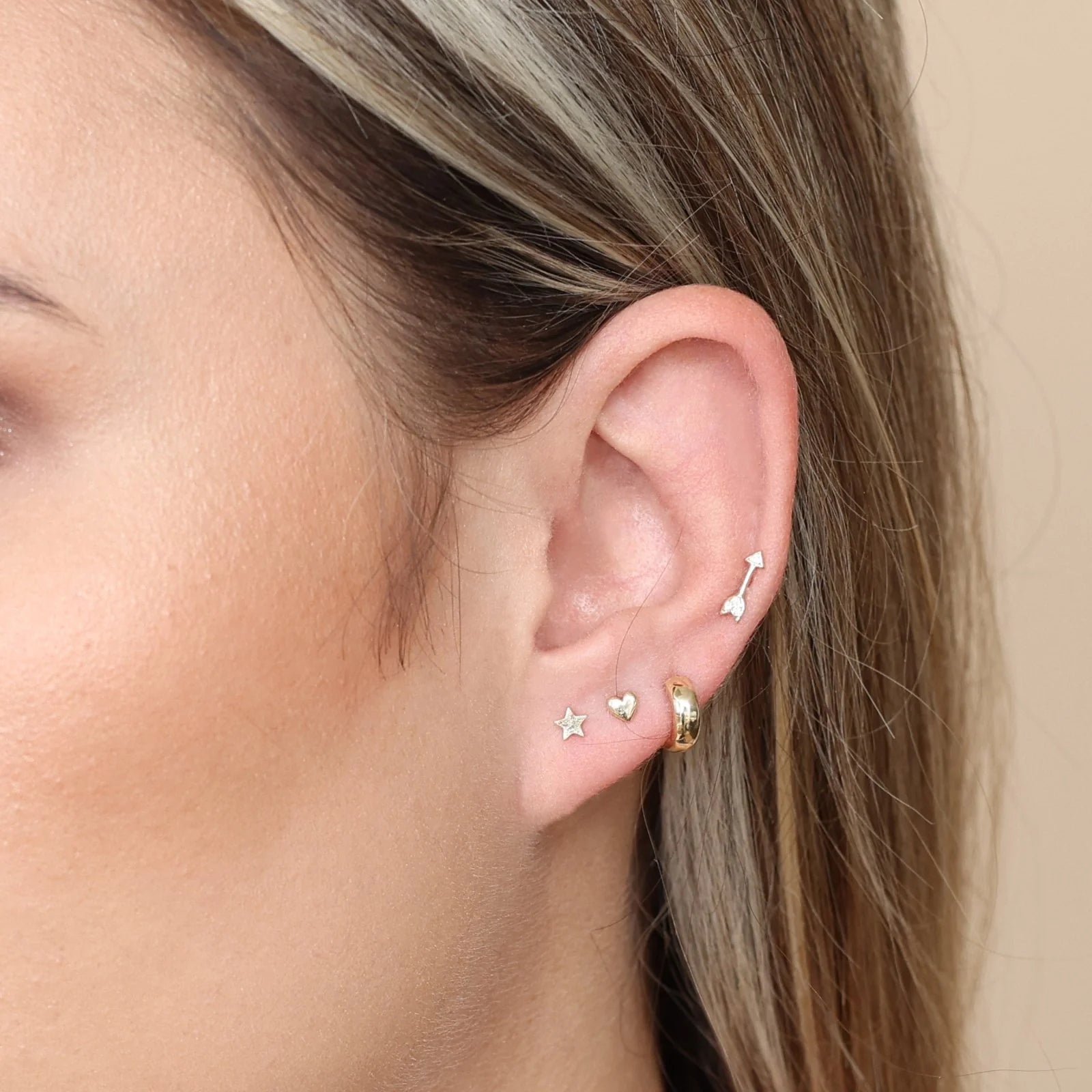 a simple earring stack with an arrow stud and heart stud