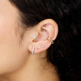 an earring stack with diamond and gold studs and an ear cuff