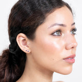 a model with blue and gold stud earrings