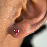 a close up of a persons ear with a red stone