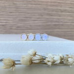 four pink opal studs on a white surface