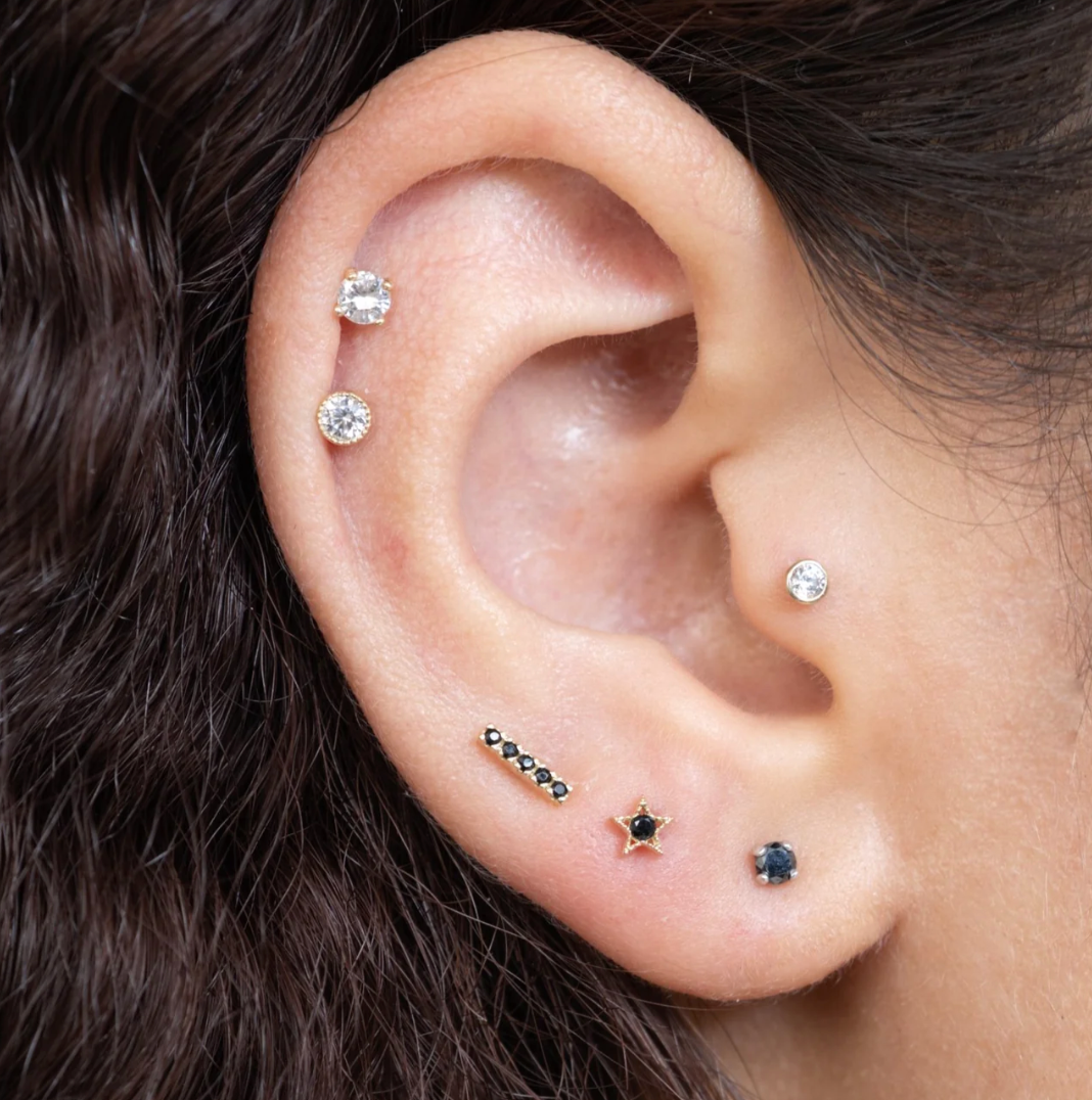 model wearing a variety of diamond and gemstone stud earrings